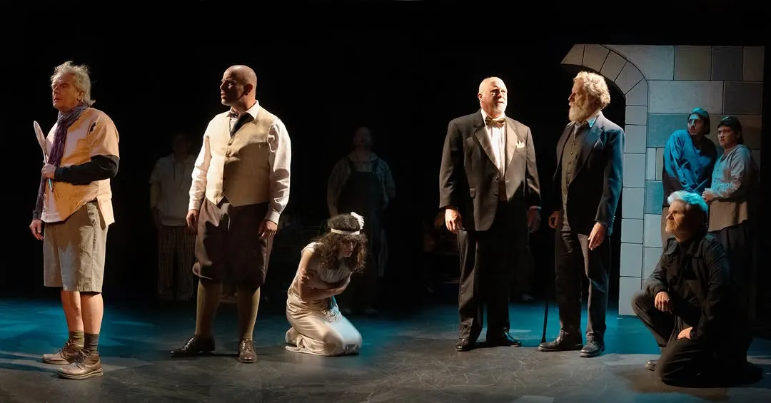 The ensemble on stage, with one performer kneeling at the centre.