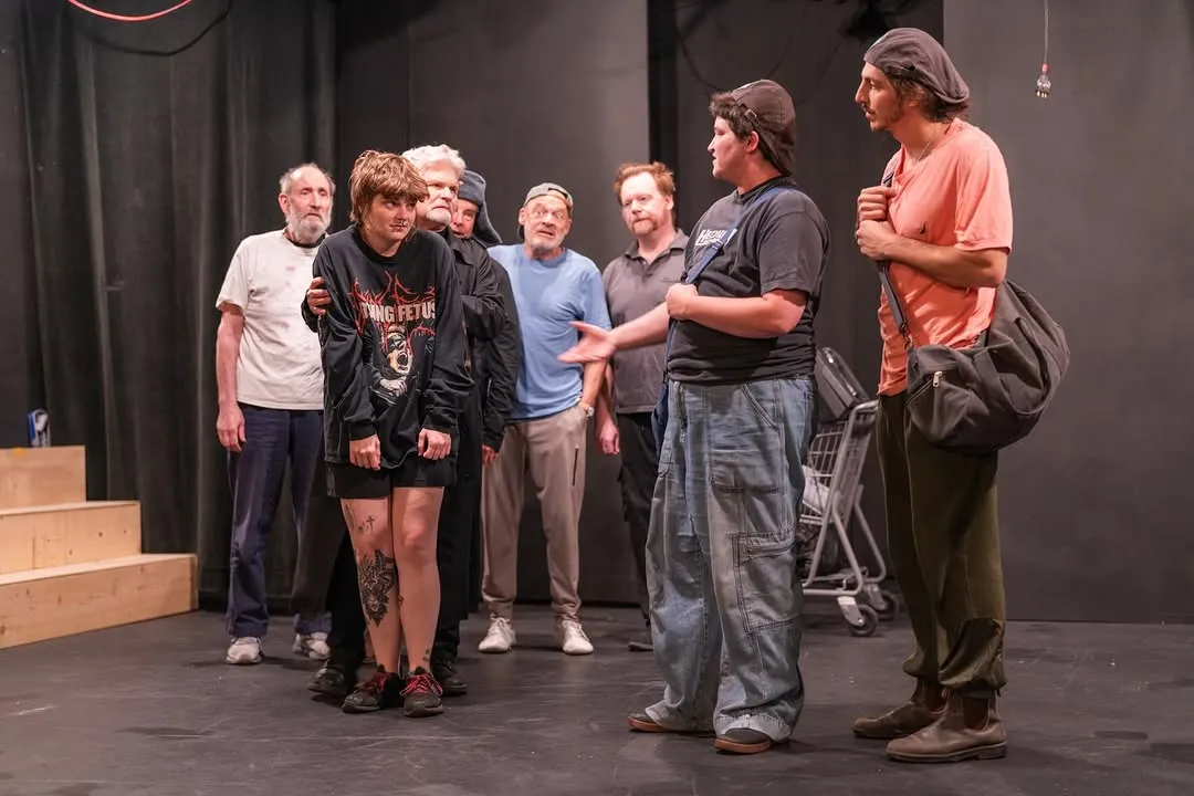 Cast members working through a scene on the theatre stage.