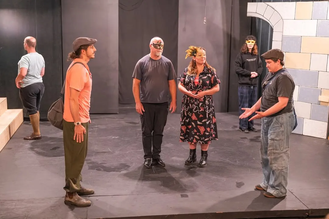 Performers rehearsing in front of the developing set.
