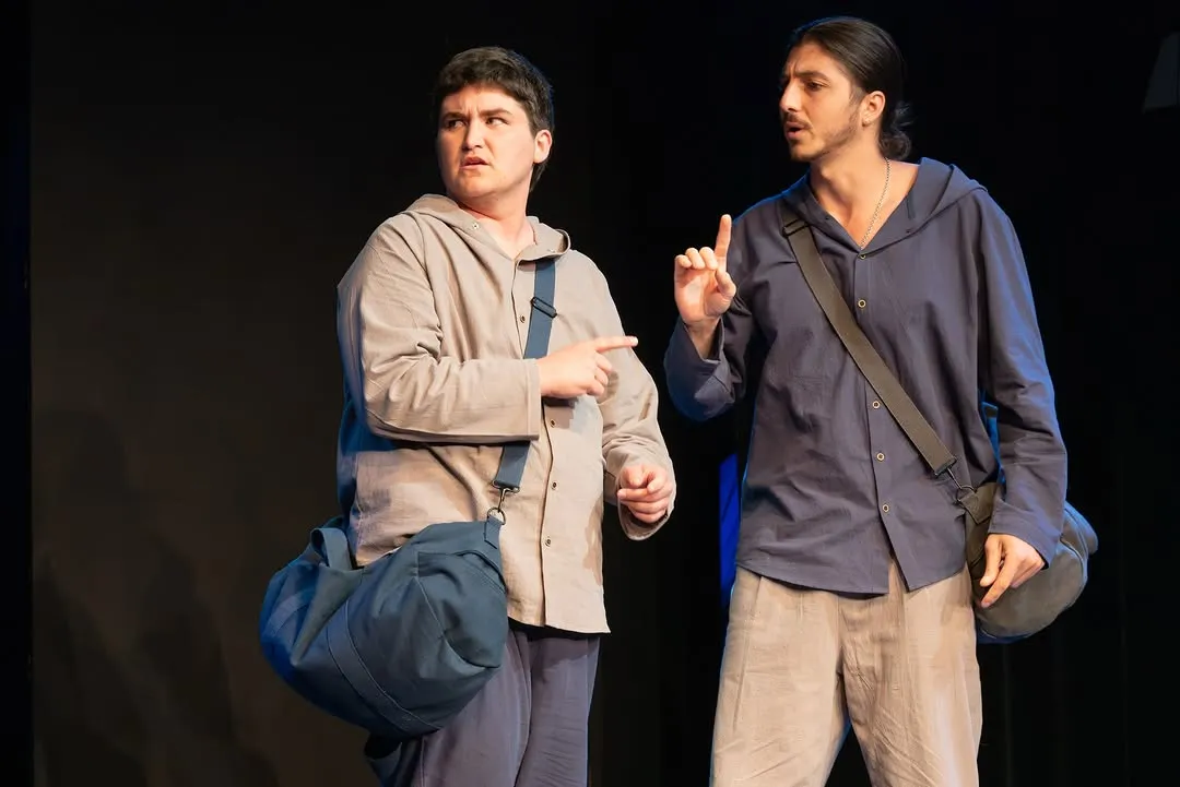 Rosencrantz and Guildenstern standing together on stage in their costumes.