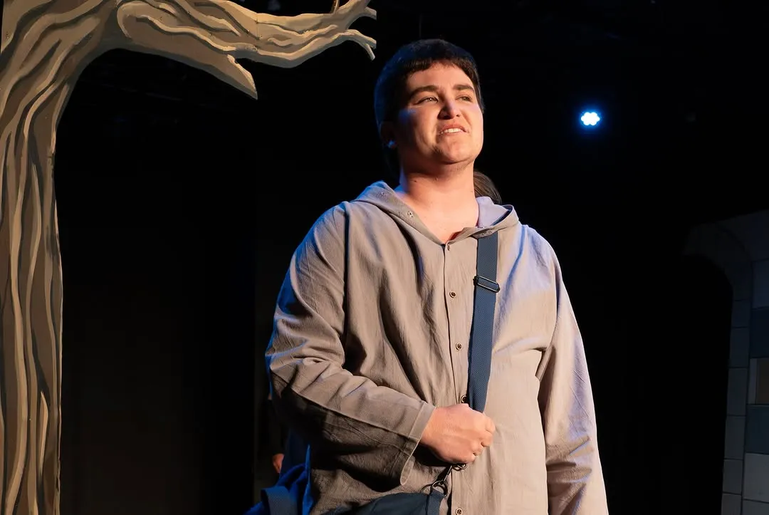 Close-up of a performer in a blue tunic on stage.