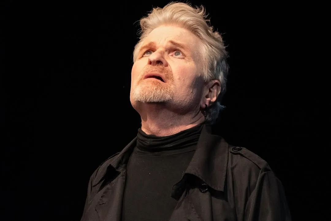 Close-up of a performer looking upwards under the stage lights.