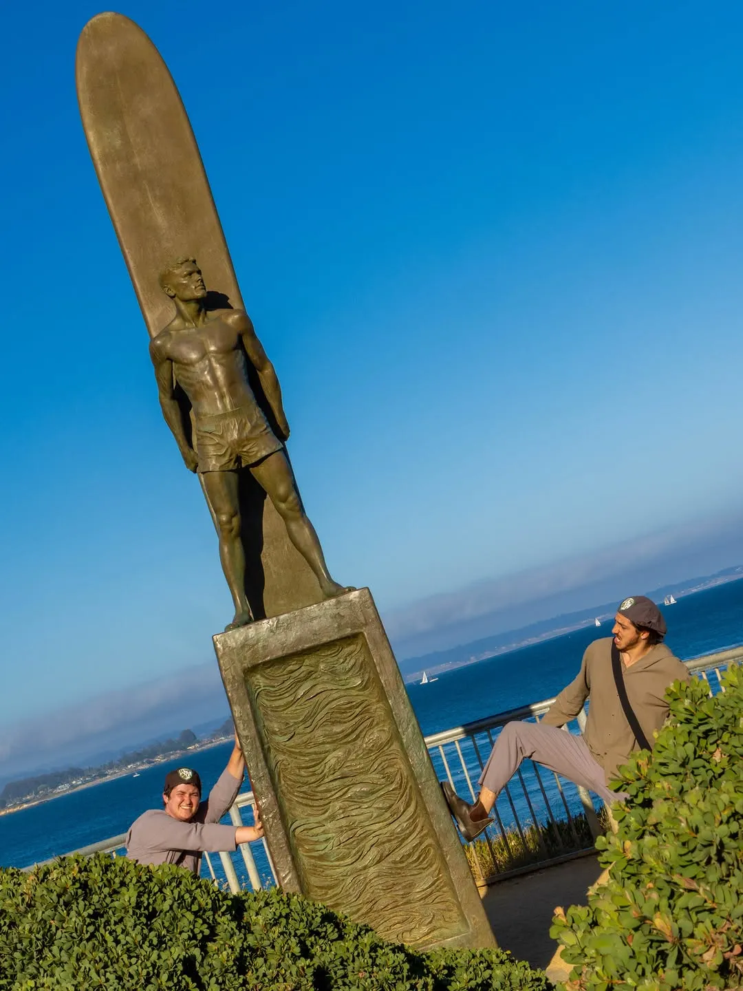 Rosencrantz and Guildenstern beside a tall outdoor sculpture.
