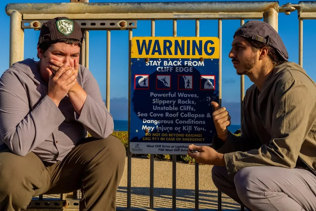 The two leads beside a parking meter and a warning sign.